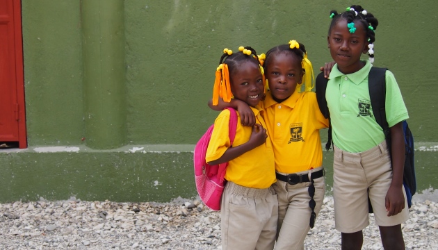 Kinderen in schooluniforms buiten schoolgebouw