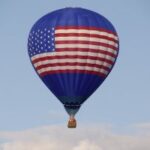 Luchtballon met Amerikaanse vlagontwerp in blauwe hemel.