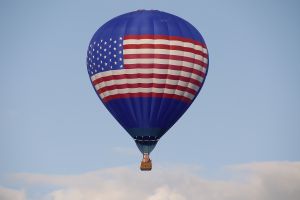 Luchtballon met Amerikaanse vlagontwerp in blauwe hemel.