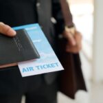 Man met vliegticket en paspoort in hand.