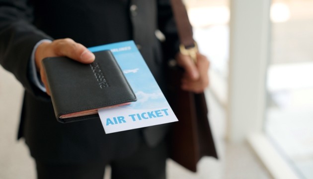 Man met vliegticket en paspoort in hand.