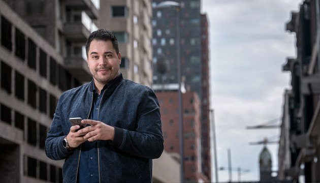Man met telefoon in stedelijke omgeving