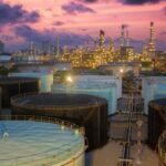 Olieopslag bij zonsondergang in industriële raffinaderij.