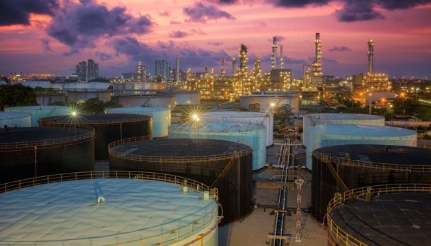 Olieopslag bij zonsondergang in industriële raffinaderij.
