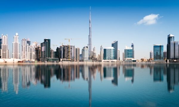 Skyline van Dubai met reflecties in water.
