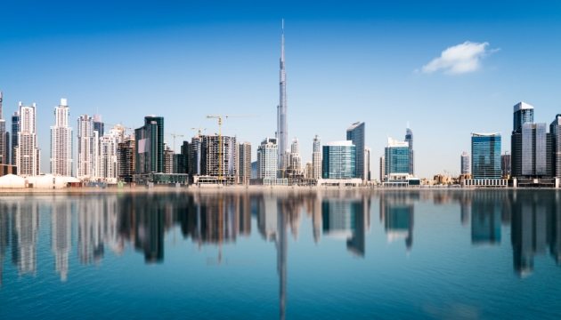 Skyline van Dubai met reflecties in water.
