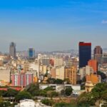 Uitzicht op skyline van grote stad met bergen.