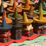 Rijen van gekleurde houten beeldjes met hoedjes