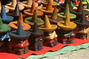 Rijen van gekleurde houten beeldjes met hoedjes
