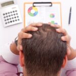 Gestreste zakenman met rapport, rekenmachine en pen.