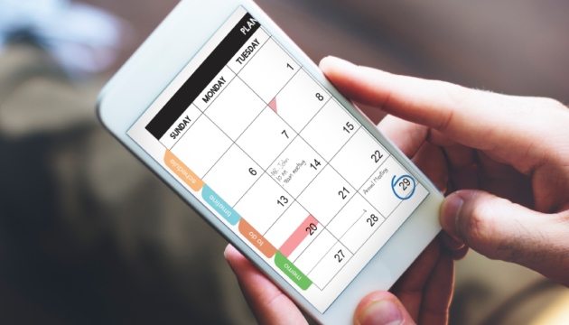 Persoon gebruikt kalender op smartphone.