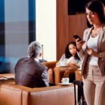 Zakelijke vrouw met smartphone in luchthavenlounge.