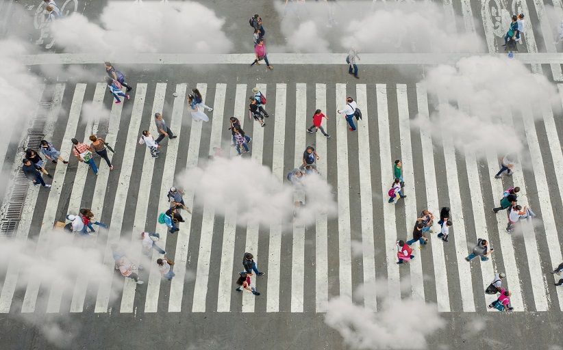 Mensen oversteken op druk zebrapad, wolkeneffecten.