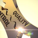 Gouden tandwielen met de woorden 'controle' en 'kwaliteit'.