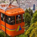 Oranje kabelbaan met stadspanorama en bossen