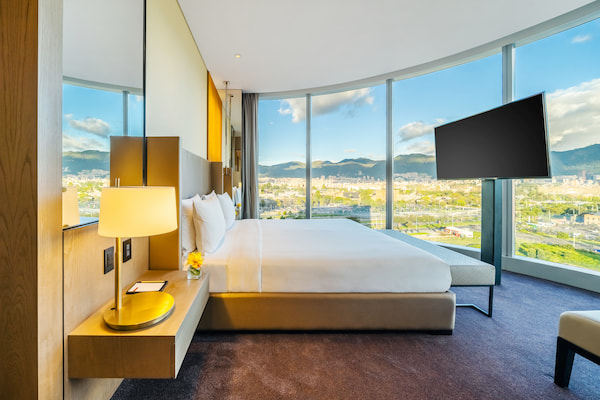 Luxe hotelkamer met panoramisch uitzicht op stad.
