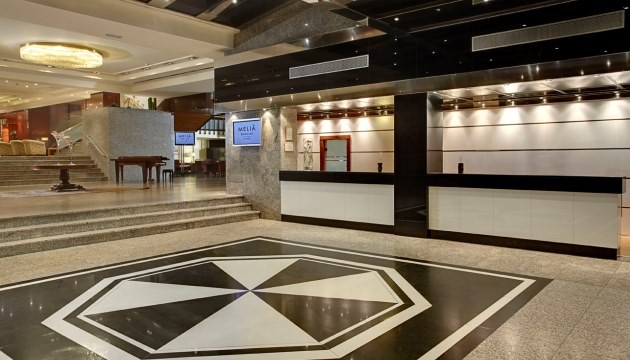 Luxe hotelreceptie met moderne inrichting en marmeren vloer.