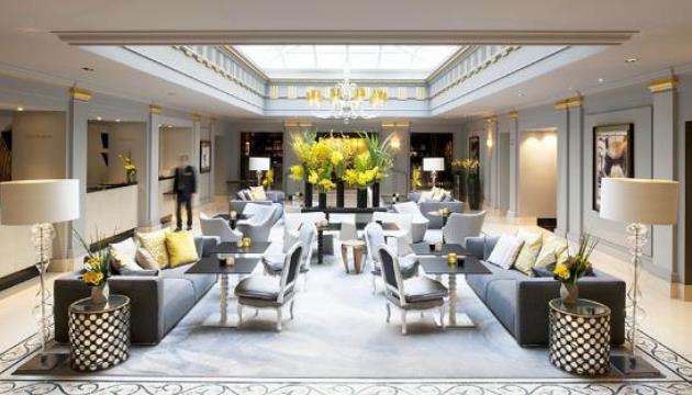 Luxueuze hotellobby met zitruimte en bloemendecoratie.