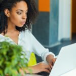 Vrouw werkt geconcentreerd op laptop in kantooromgeving