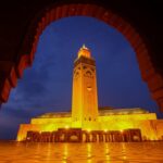 Verlichte moskee bij zonsondergang in Marokko.