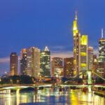 Skyline van Frankfurt bij nacht met rivierzicht.