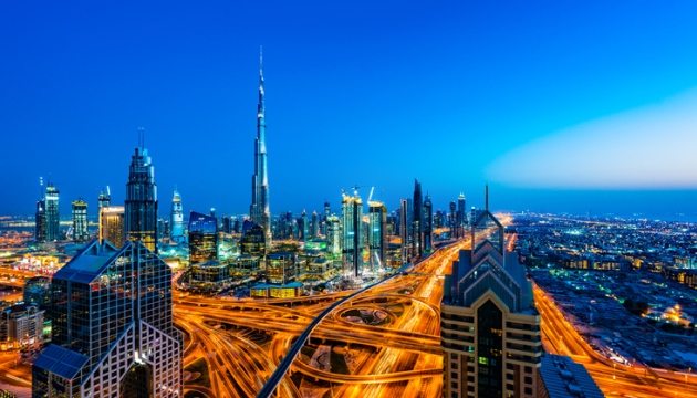 Nachtzicht van Dubai met verlichte skyline en wegen.