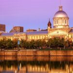 Historisch gebouw bij schemering weerspiegeld in water.