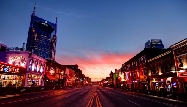 Nashville straat bij zonsondergang met verlichte gebouwen.