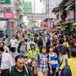 Drukke straat in Hongkong vol mensen en borden.
