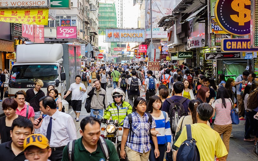 Drukke straat in Hongkong vol mensen en borden.