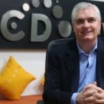 Man voor BCD Travel-logo met gele kussens.