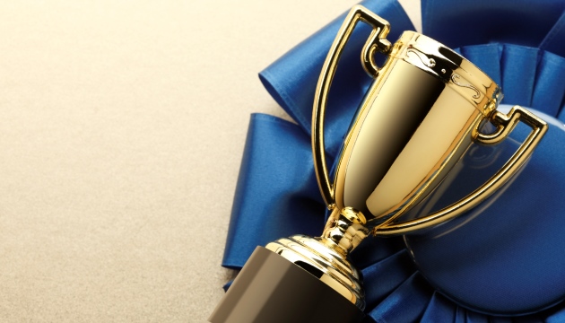 Gouden trofee met blauwe lint op tafel