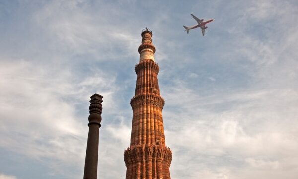 Vliegtuig boven Qutab Minar in Delhi, India