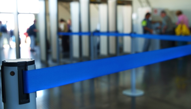 Blauwe beveilingshek bij controlepoortjes op luchthaven.