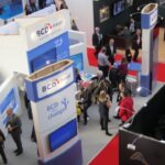 Luchtzicht op drukke beursstand met bezoekers.