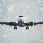 Vliegtuig vliegt door sneeuwstorm, voorkant zichtbaar.