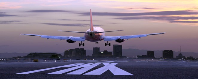 Vliegtuig landt op luchthaven tegen zonsondergang.