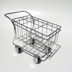 Leeg metalen winkelwagentje op witte achtergrond.