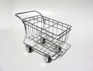 Leeg metalen winkelwagentje op witte achtergrond.