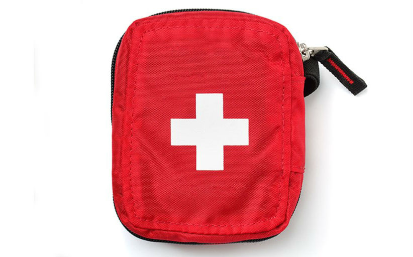 Rode EHBO-kit met wit kruis symbool.