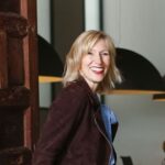 Vrouw lacht bij houten deur in modern interieur