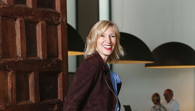 Vrouw lacht bij houten deur in modern interieur