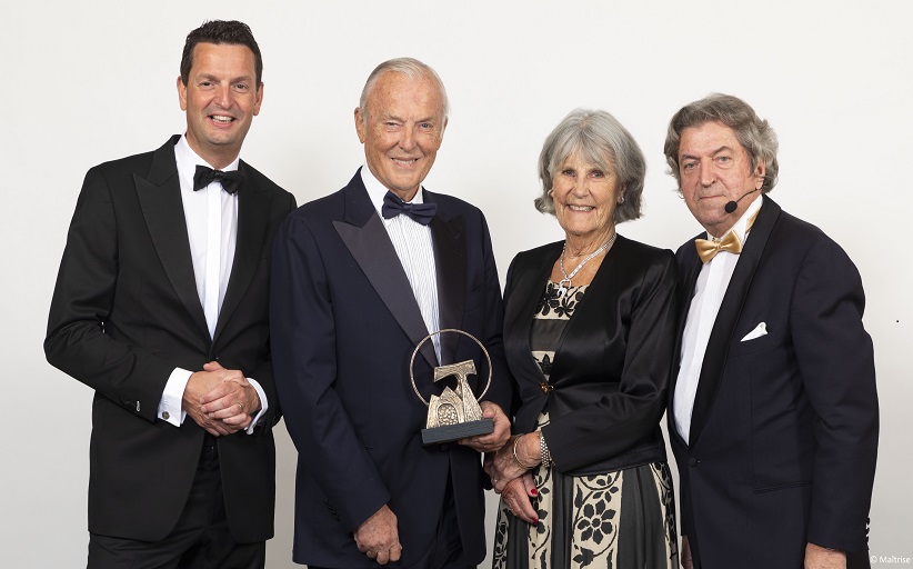 Vier personen in avondkleding met een trofee.