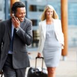 Zakelijke reizigers met rolkoffers op luchthaven