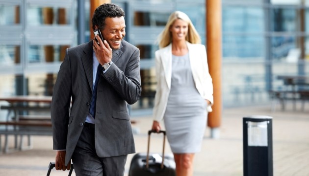 Zakelijke reizigers met koffers, pratend onderweg.