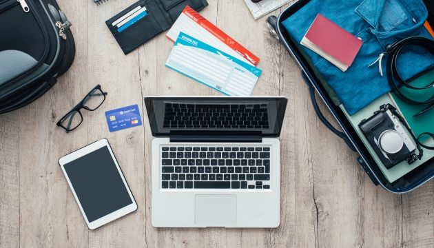 Reisplanning met laptop, kaartjes en koffer