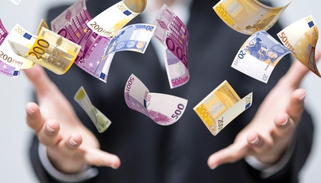 Vliegende eurobiljetten tussen open handen.