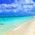 Tropisch strand met hangmat en palmbomen.