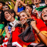 Cheering international sports fans in colorful attire.