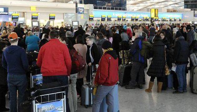 Drukke rij bij incheckbalies op luchthaven.